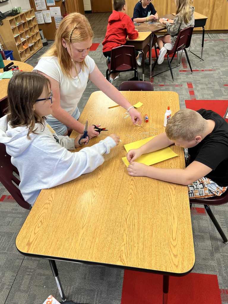 Students using papers to build 