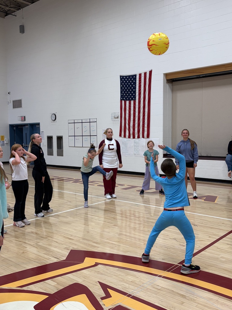 Students in a gym hitting a ball in the air
