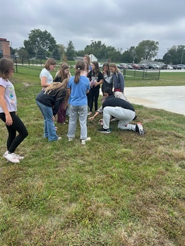 Students gathered watching a snake 