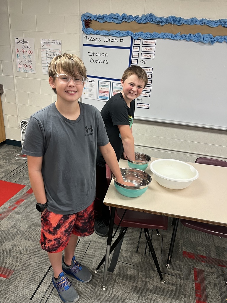 Boys doing experiment with hands in water in bowls 