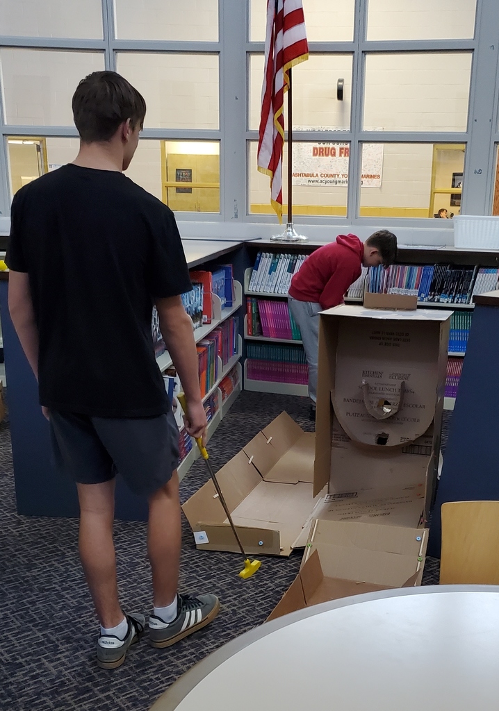 Boys playing through a skee ball type mini golf