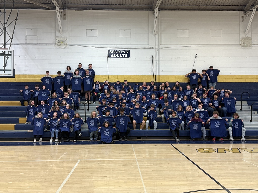 Students holding up taco bell Spartan t-shirts