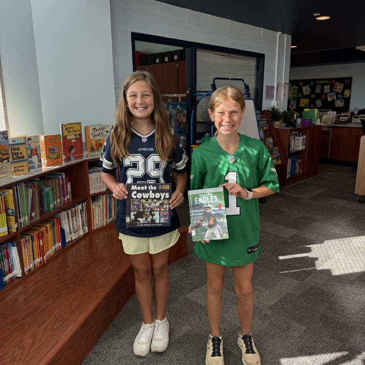 two girls, one with an eagles shirt, and one with a cowboys shirt
