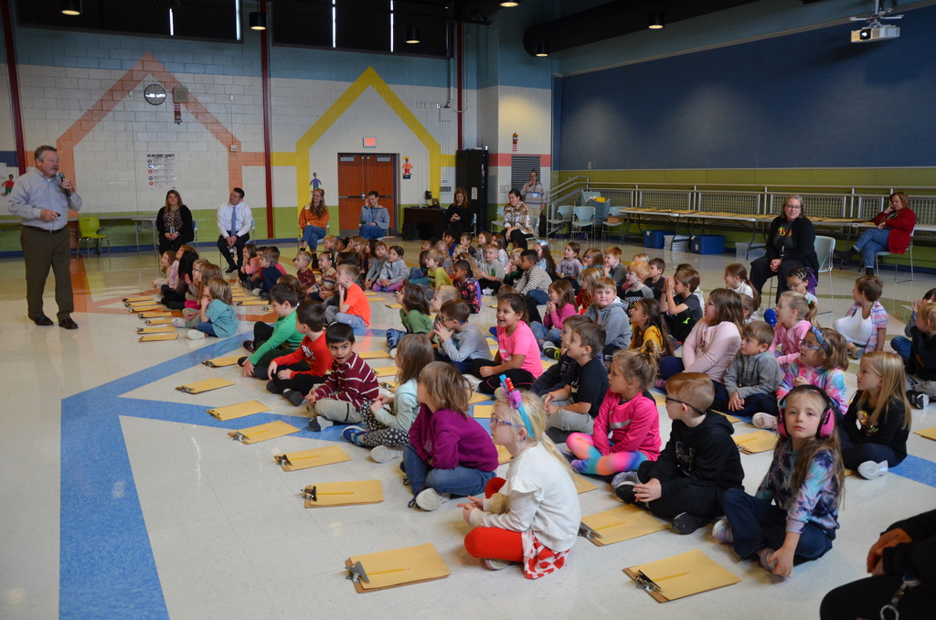 an auditorium full of students listening to Lee Harper doing his presentation