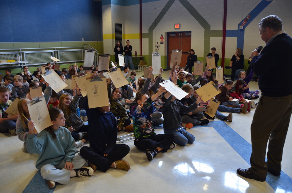 Lee Harper with a group of students holding up their artwork