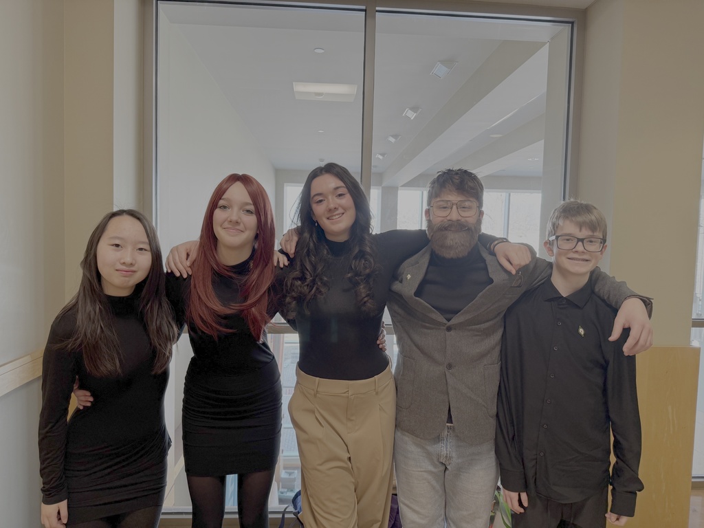 students standing in front of a window