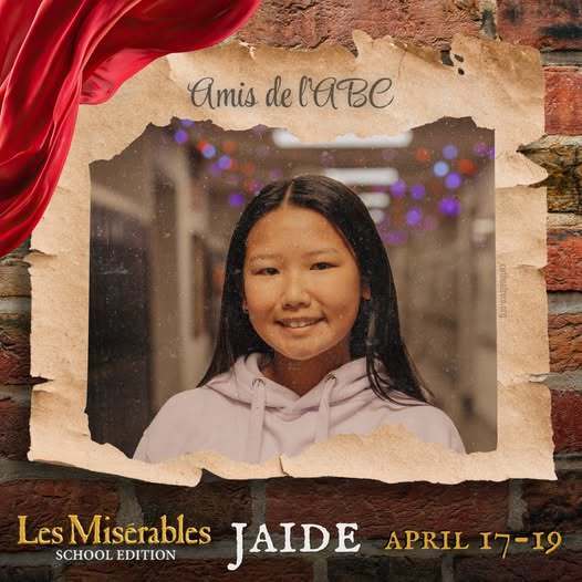 A promo graphic for Les Misérables: School Edition featuring a student cast member’s headshot. The student is centered in a softly lit indoor setting and framed within a torn parchment-style border against a brick wall background, with a red draped fabric accent in the corner. The top of the image reads “Amis de l’ABC,” and the bottom includes the show title and performance dates: April 17–19.