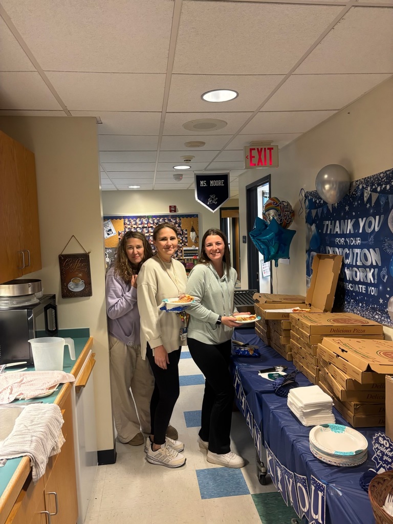 teachers getting pizza from a table 