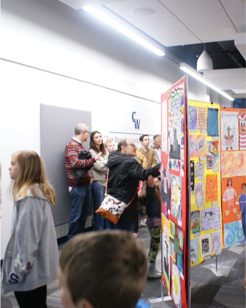 Photographs of families and community members viewing student artwork at the District Wide art show
