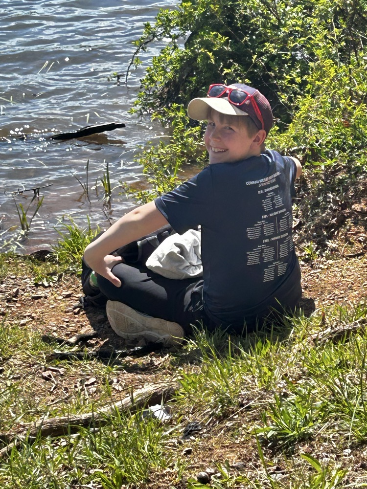 student sitting near a lake