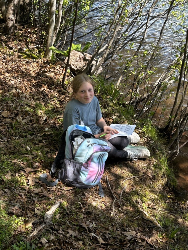 student sitting near a lake