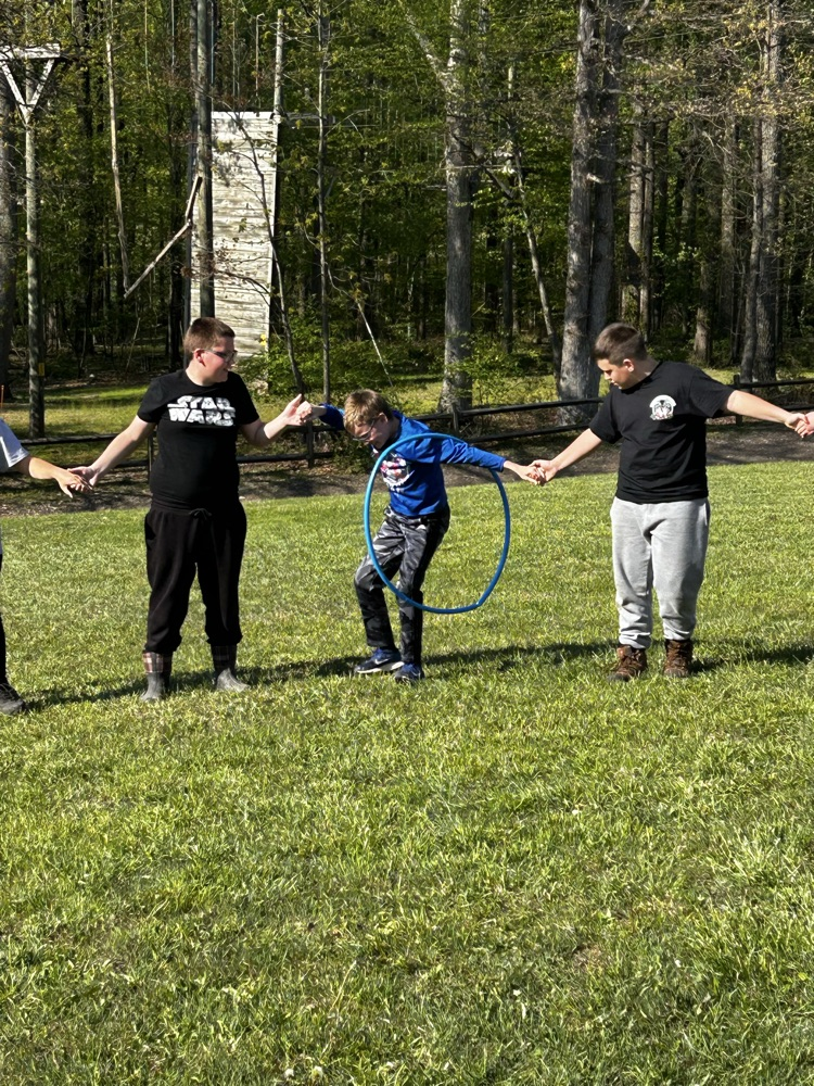 students passing a hula hoop with connected arms
