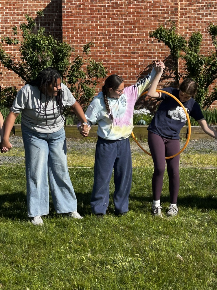 students passing a hula hoop with connected arms