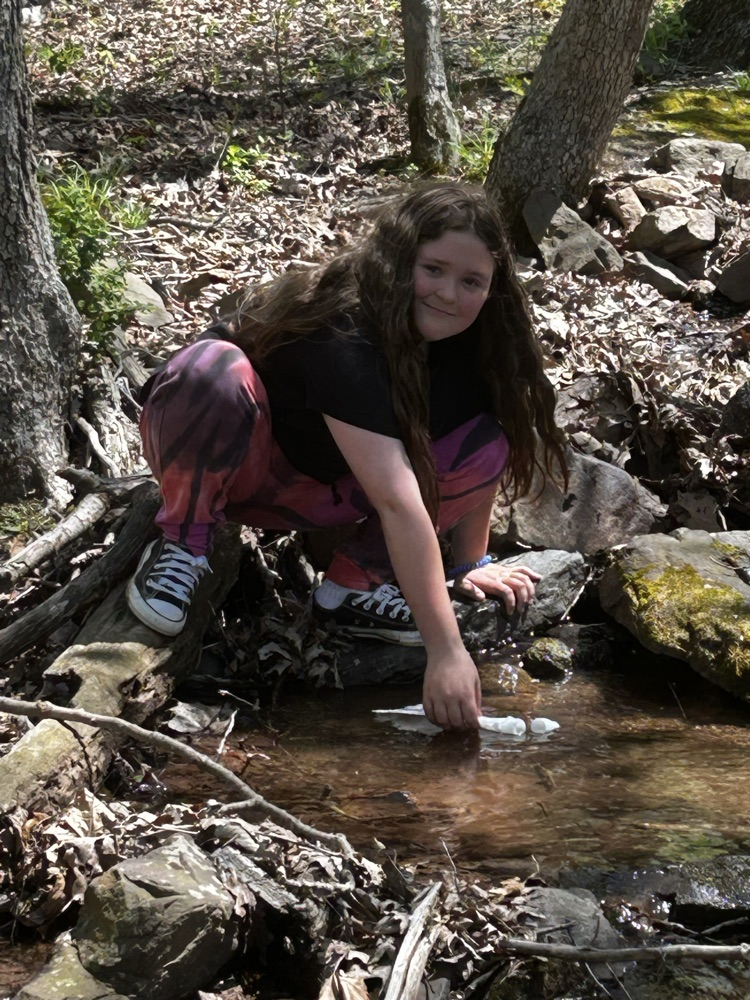 student at a creek