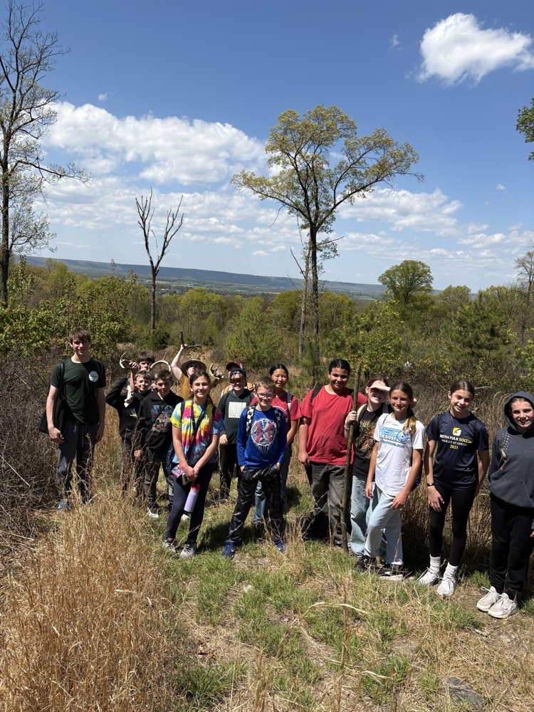 students after a hike standing on a hilltop