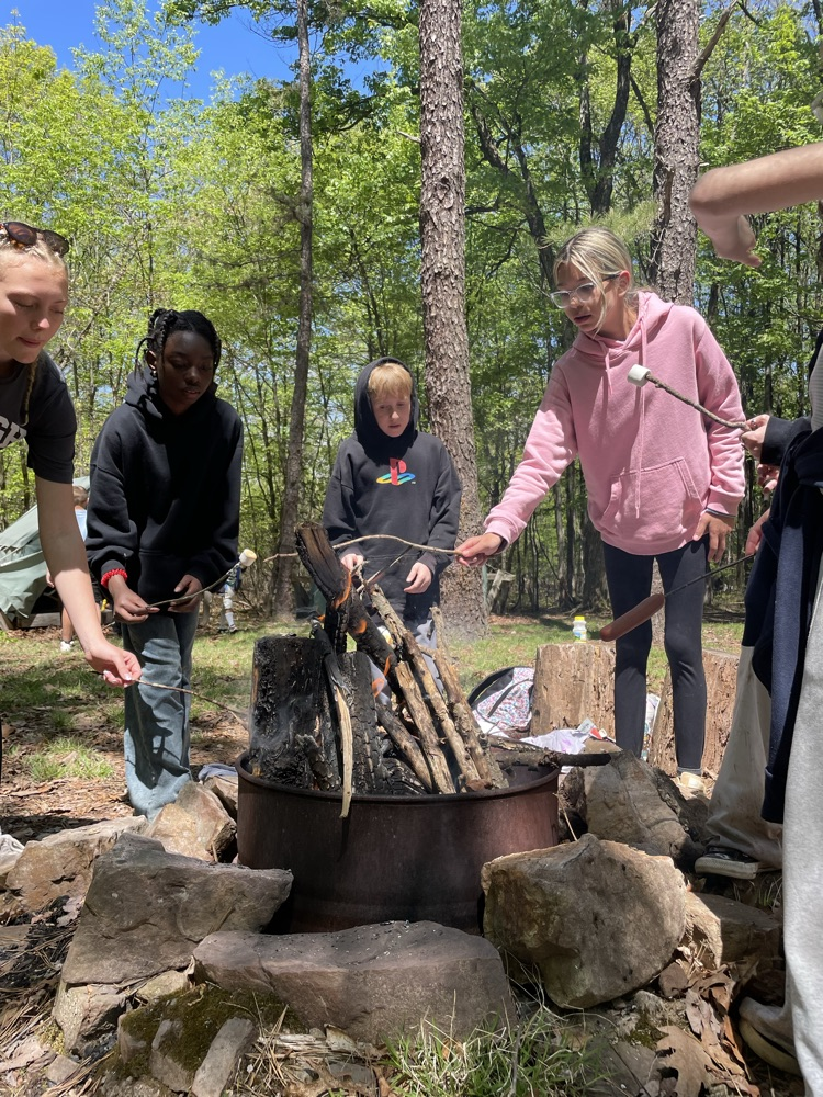 students cooking at a campfire