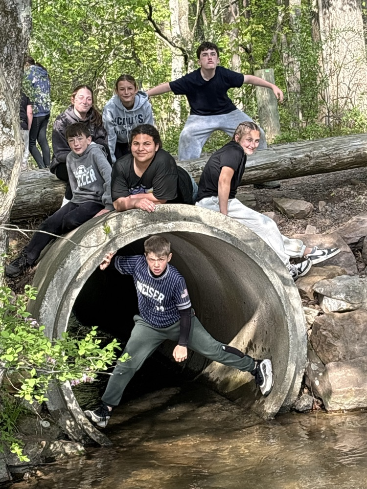 students in and on a concrete pipe