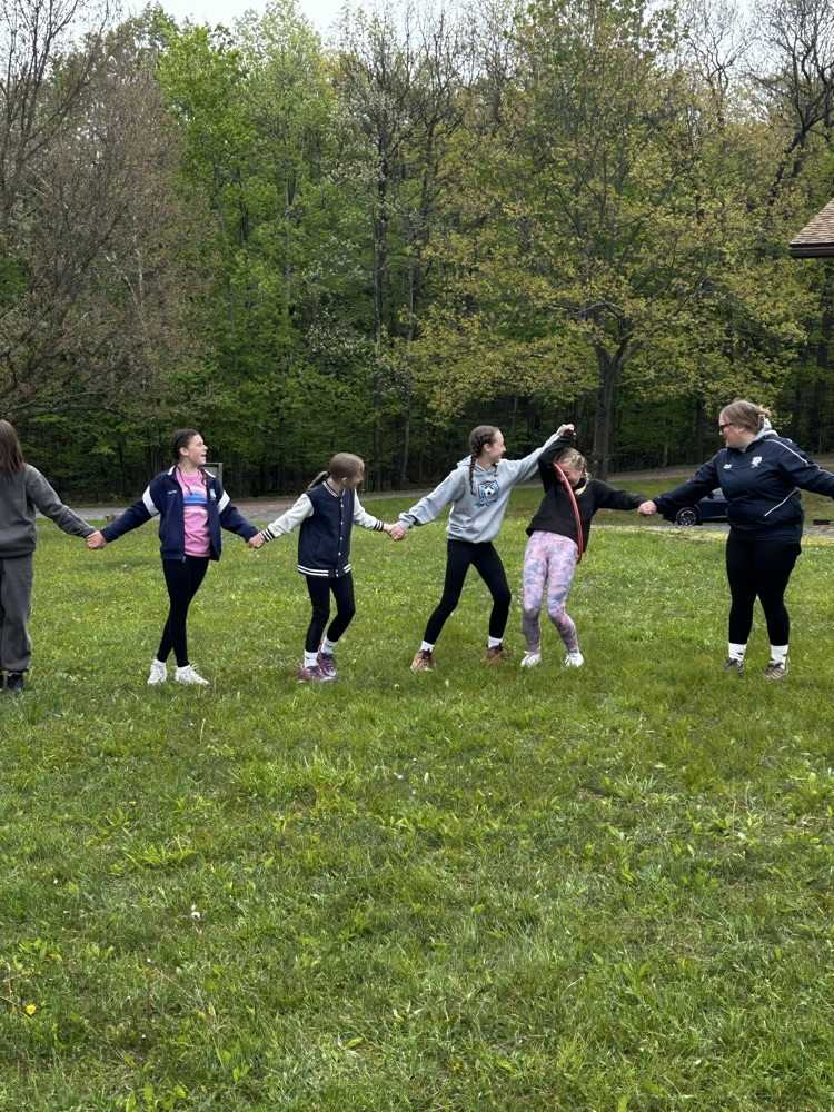 students using a hula hoop for a team building activity