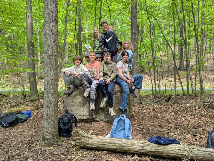 students sitting on a bolder