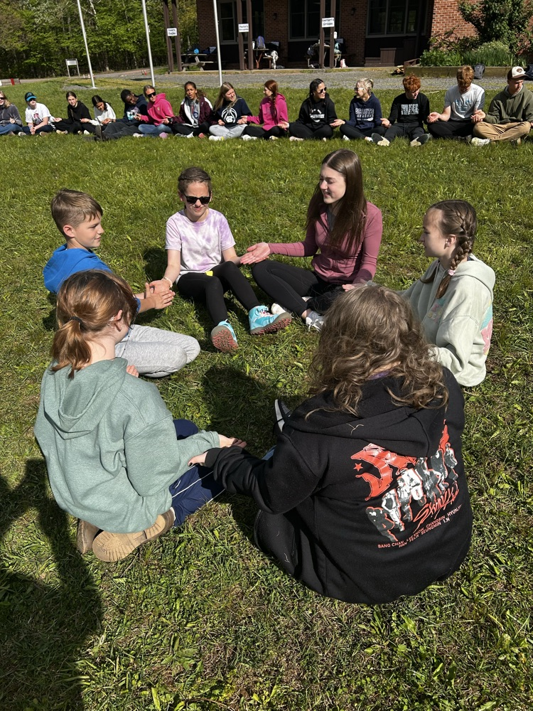 students in a circle playing a clapping game