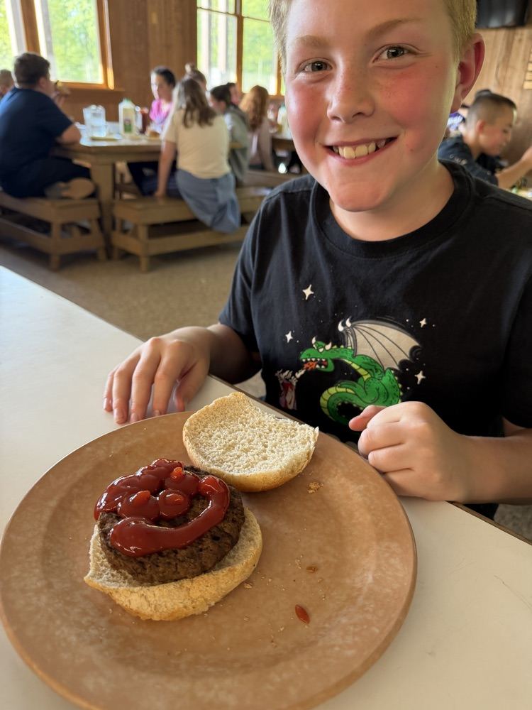 student with a hamburger covered in catsup