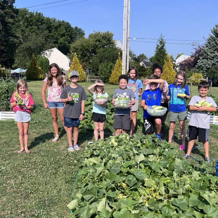 students standing with their cucumbers they harvested