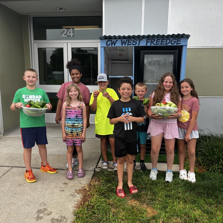 students standing in front of the freedge with crops we harvested