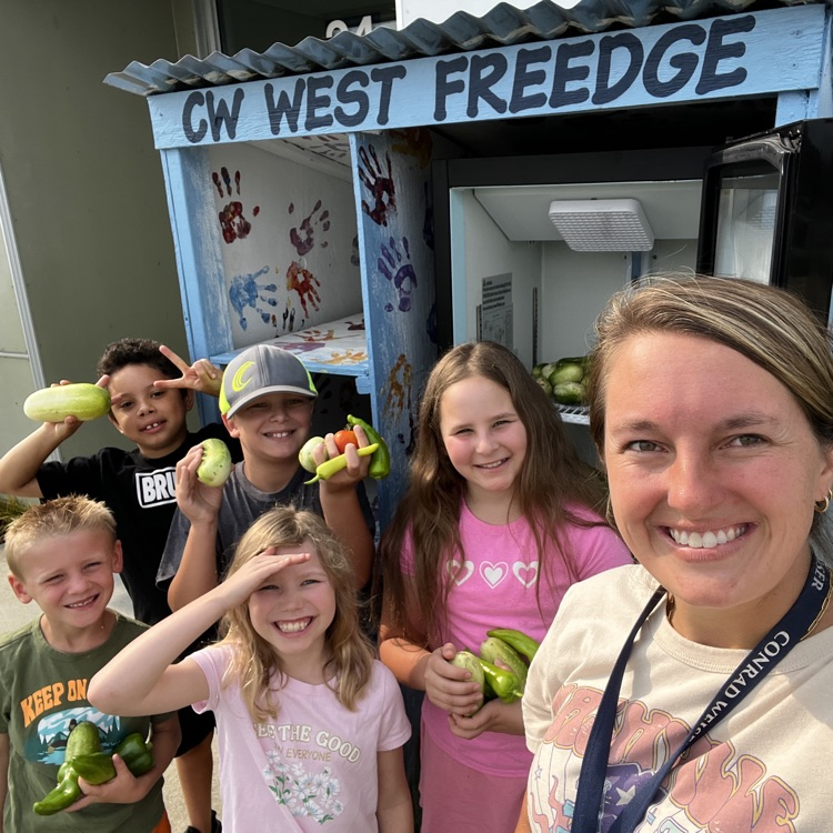 teacher and students standing in front of a Fridge