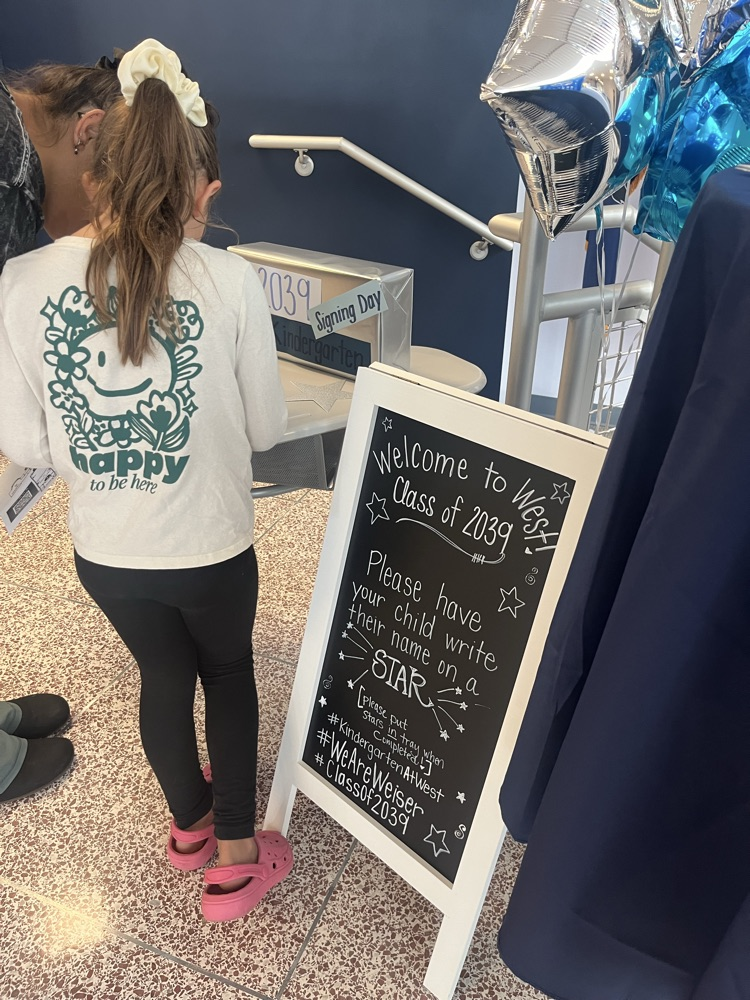 student signing their name to a star
