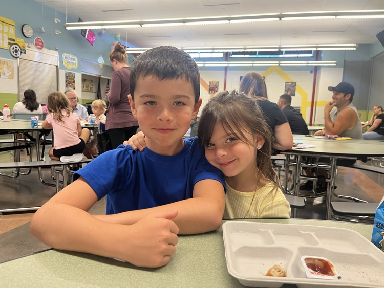 student eating lunch with her big brother
