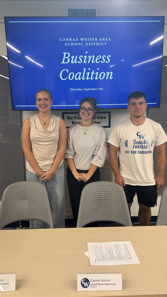 3 students posing in front of the tv screen