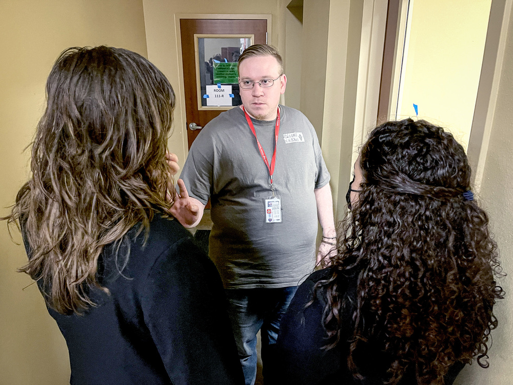 Joseph Collatos talking to two debate students.