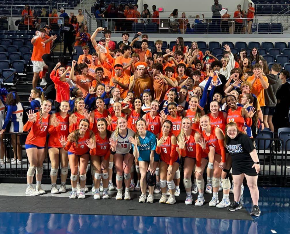 GOHS volleyball team standing in front of students and cheerleaders.