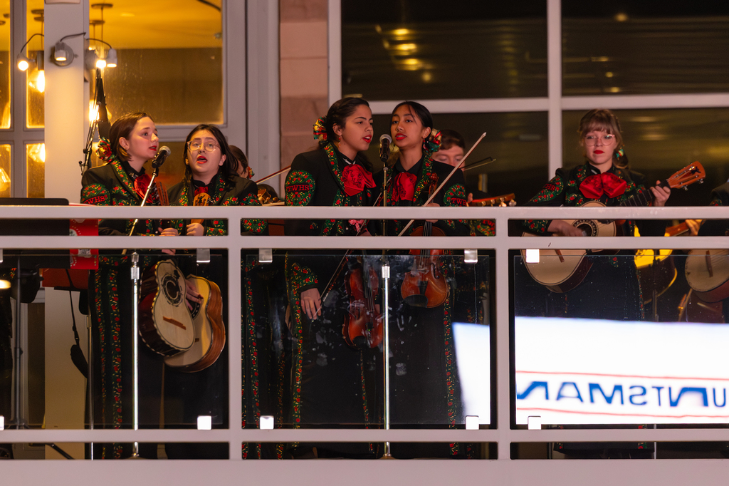 Members of a student Mariachi band peform on a balcony.