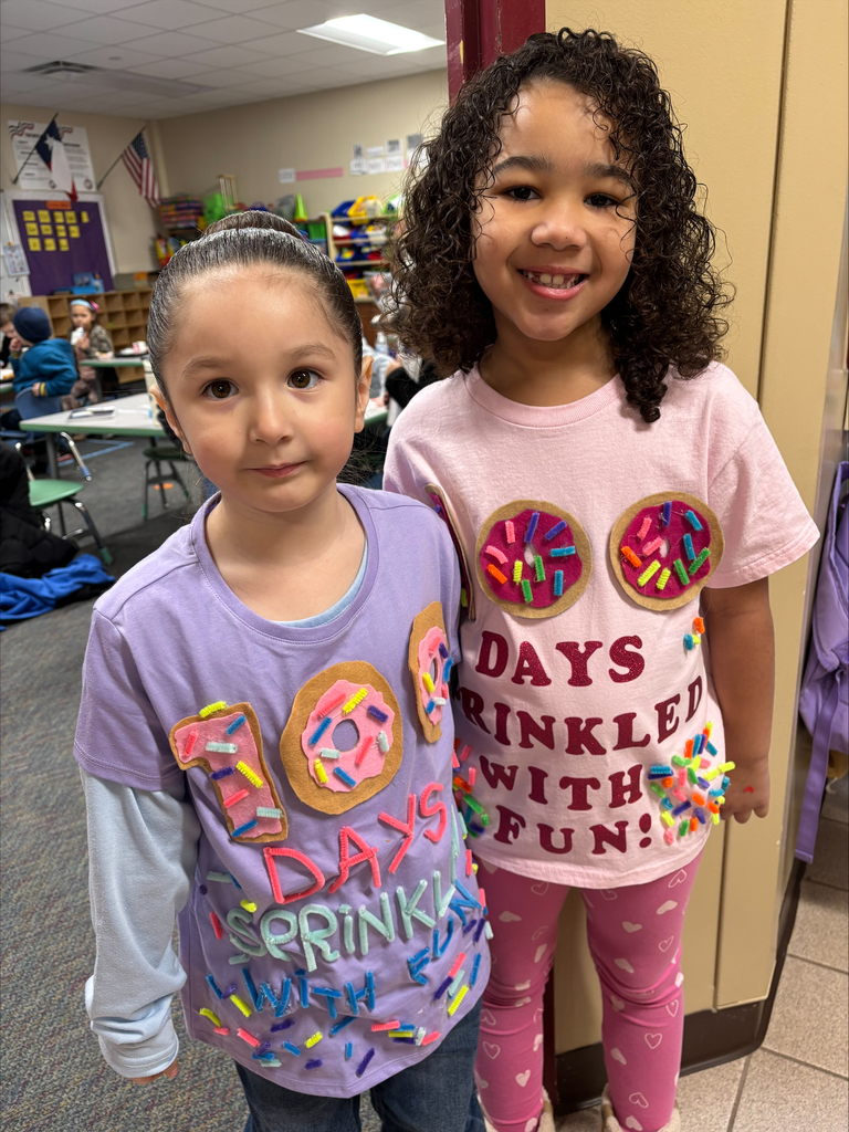 Two elementary students wearing a shirt that reads '100 Days Sprinkled with Fun.'