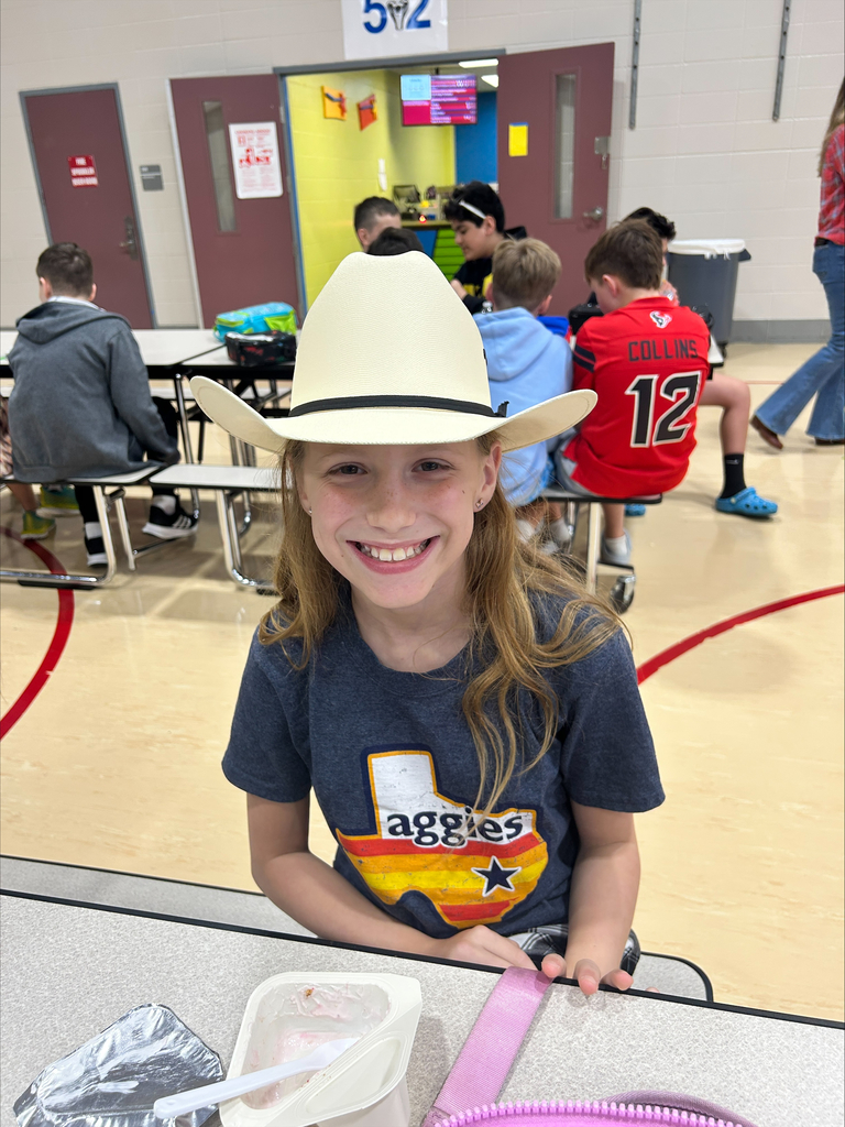 A student wearing a cowgirl hat in the cafeteria.