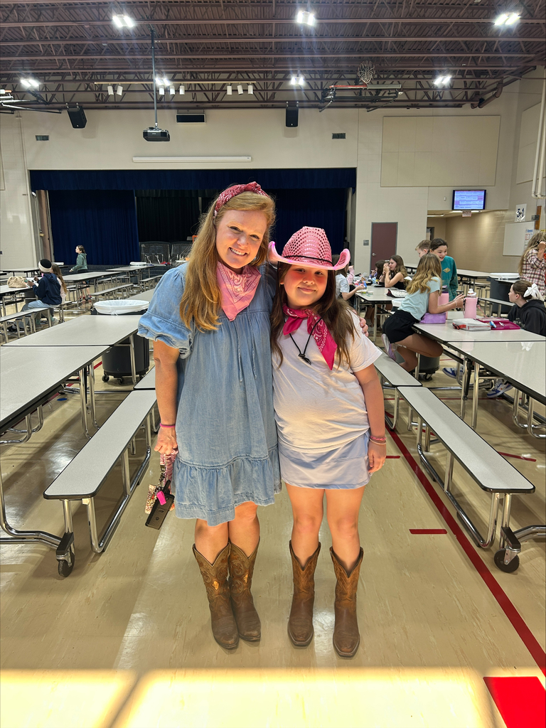 Staff member and student posing in the cafeteria for Texans Day.