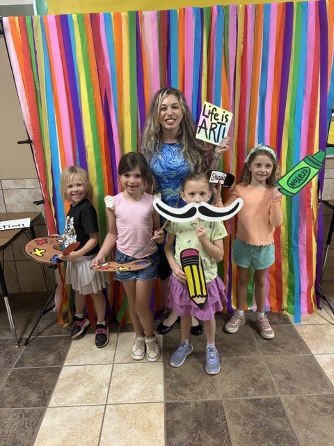 kids with teacher at art night with props