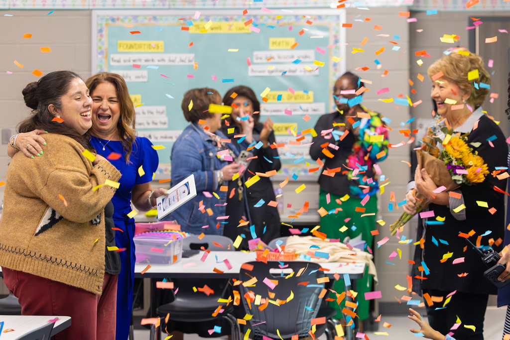 Group celebrates in classroom with confetti as staff member is recognized.