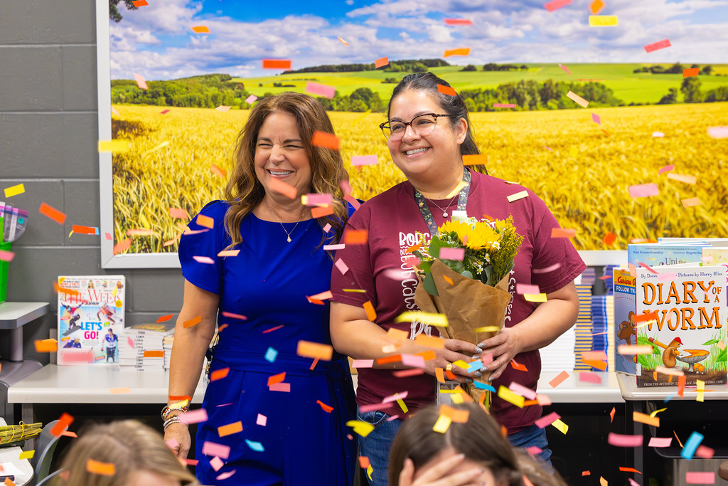 Staff celebrate in classroom as confetti falls during recognition moment.