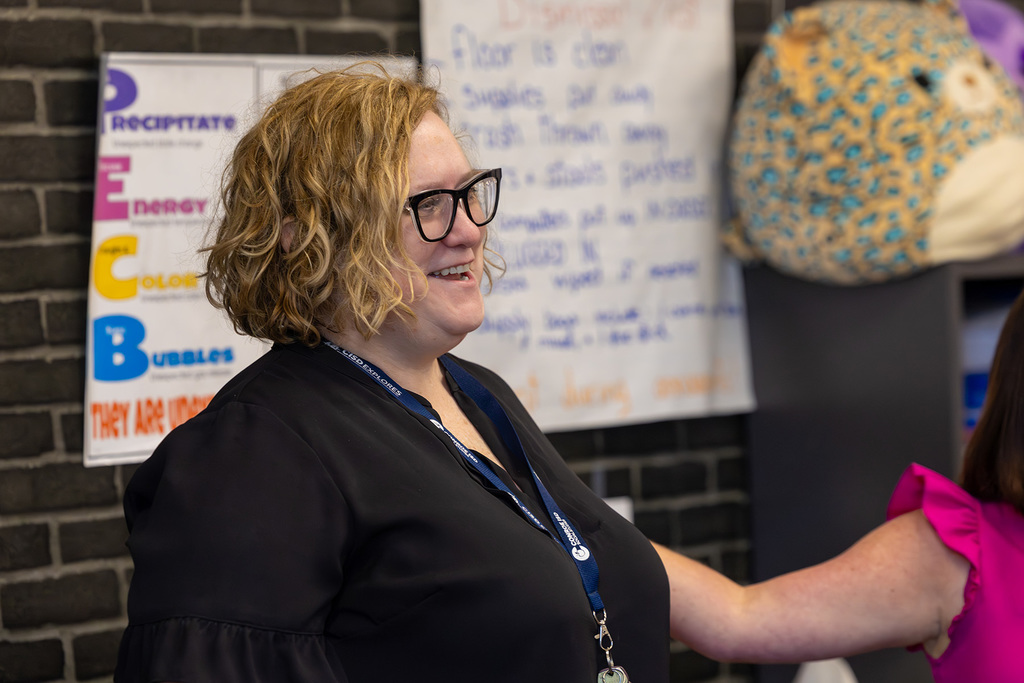 Staff member smiles during classroom recognition moment.