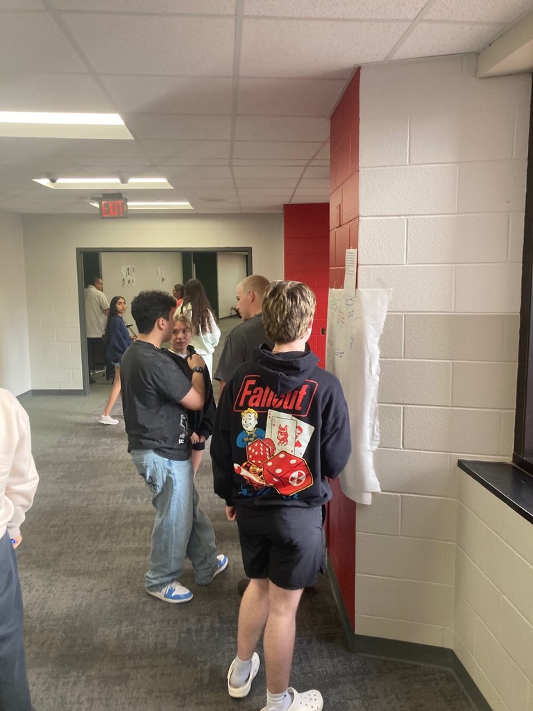 Seniors working on a gallery walk discussing ideas/topics in our next novel.