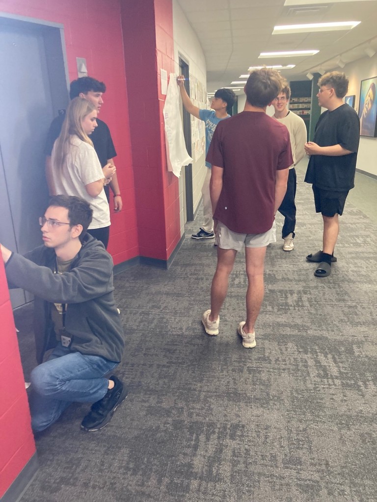 Seniors working on a gallery walk discussing ideas/topics in our next novel.