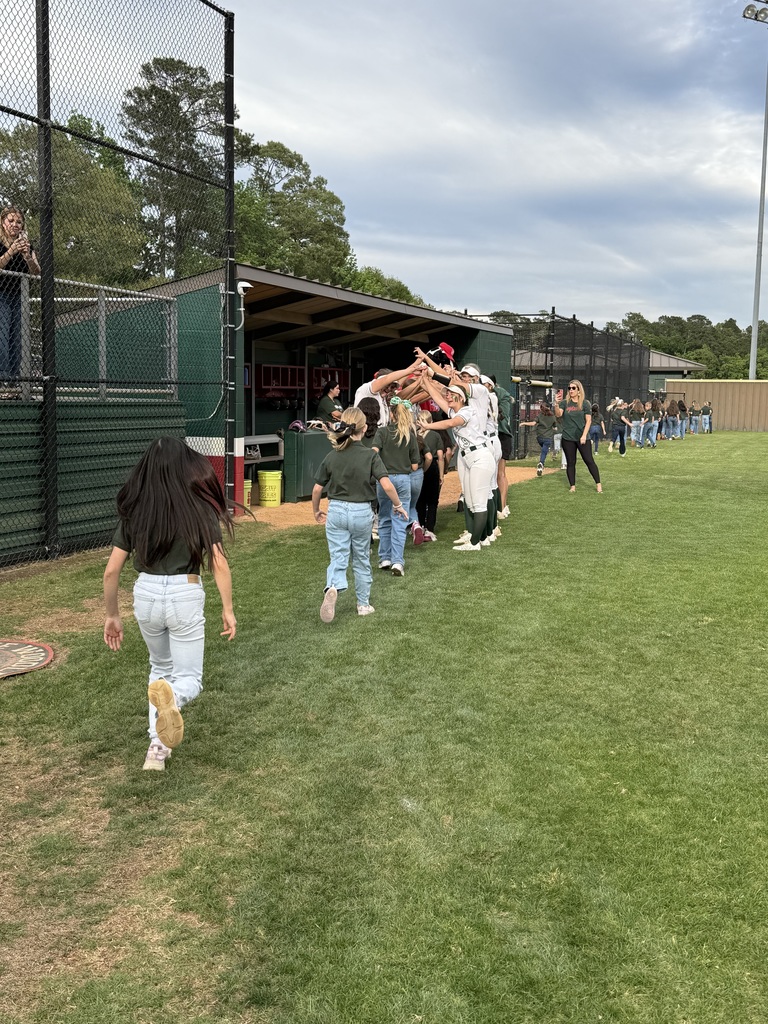 buckalew choir kids running through handmade tunnel of high school softball players