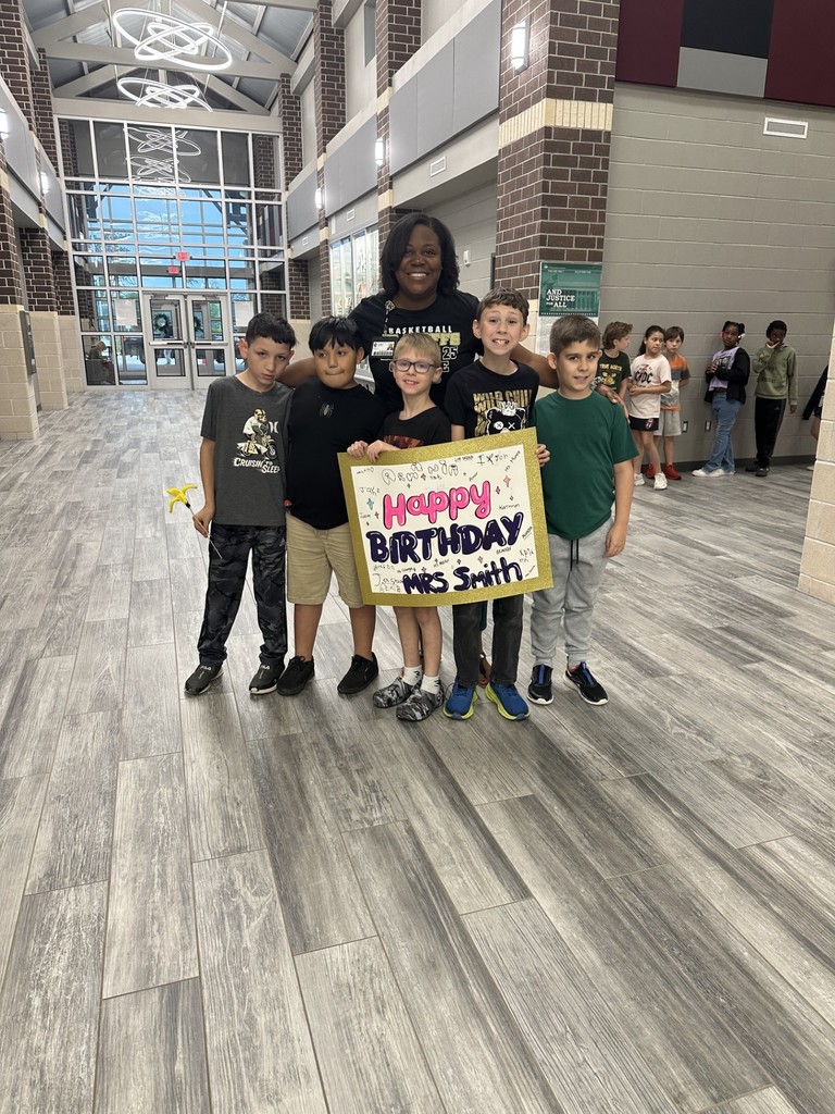 Ms. Smith with several students and a birthday banner!