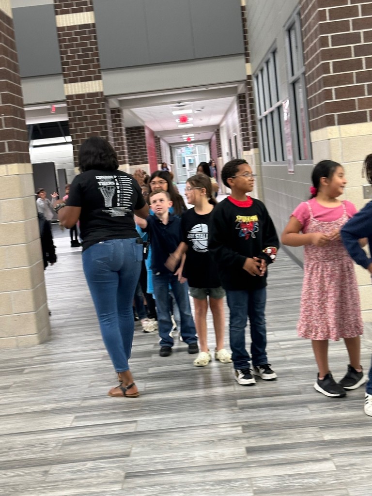 3rd graders singing to Mrs. Smith as they walk to Specials.