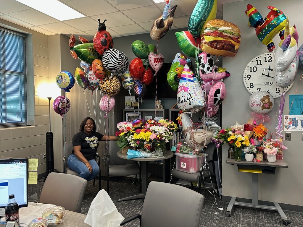 Mrs . Smith with all her treats in her office.