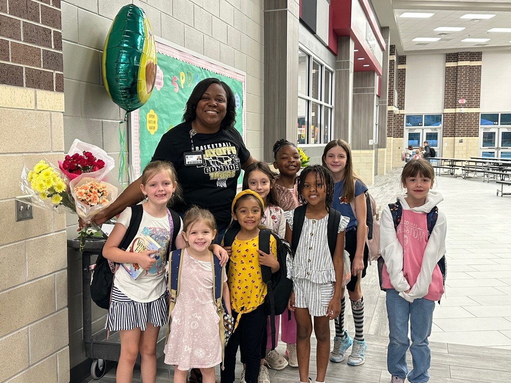 More students with Mrs. Smith bringing her flowers.