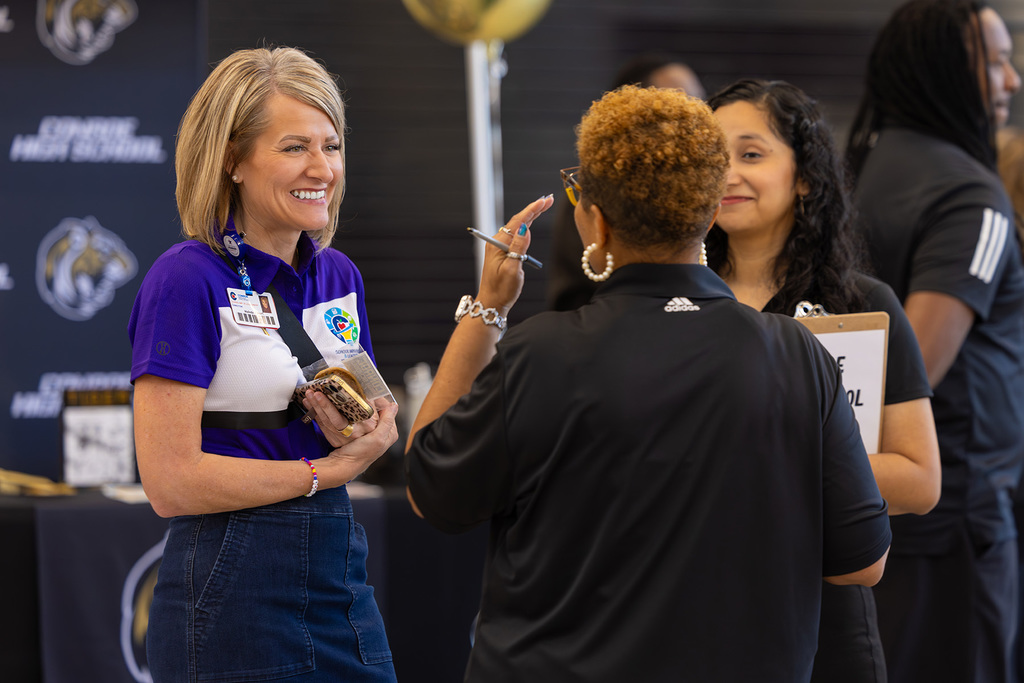 Three administrators talking during a job fair.