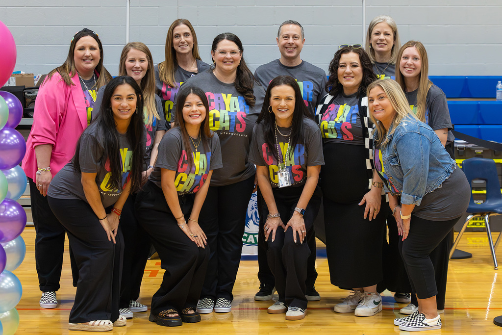 Group of 12 educators in matching gray shirts.